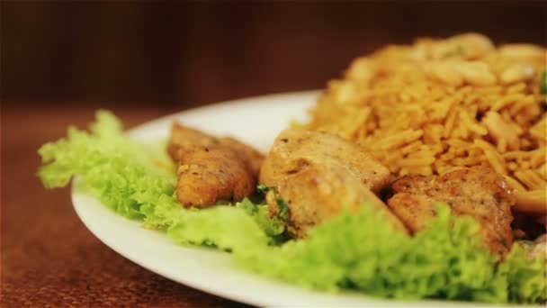 Τροφίμων, βρασμένο ρύζι με το κρέας και τα φιστίκια. Αραβικό πιλάφι με σάλτσα κρέατος και τα φιστίκια. Εθνική ασιατική και αραβική κουζίνα. Πιάτο ρύζι και το κρέας. Πιλάφι, ρύζι, ριζότο. — Αρχείο Βίντεο