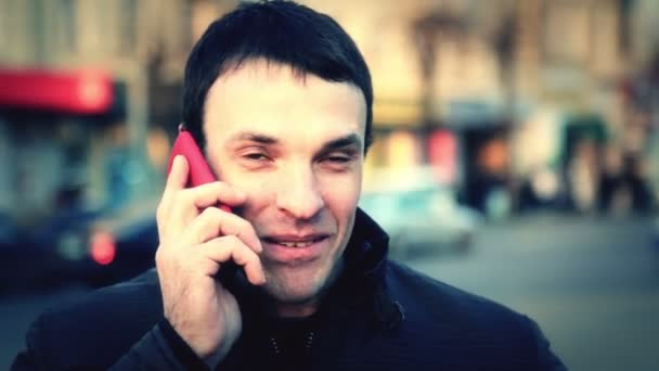 Retrato de um jovem na cidade. Um tipo caucasiano a falar ao telefone na cidade. Homem turista em outra cidade . — Vídeo de Stock
