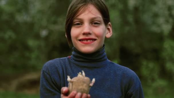 Kavkazské boy na posteli v zahradě. Dítě se zabývá jarní výsadby. Chlapec teenager v přírodě poblíž postele. Chlapec s semenáč v jejím hands.Organic zemědělství. — Stock video