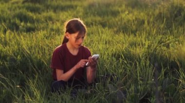 Doğa telefonda beyaz çocuk. Çocuk genç bir smartphone vasıl Günbatımı ile. Telefon fotoğrafları gün batımı ile çocuk. Doğa, insan ve teknoloji.