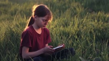 Doğa telefonda beyaz çocuk. Çocuk genç bir smartphone vasıl Günbatımı ile. Telefon fotoğrafları gün batımı ile çocuk. Doğa, insan ve teknoloji.
