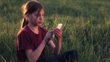 Doğa telefonda beyaz çocuk. Çocuk genç bir smartphone vasıl Günbatımı ile. Telefon fotoğrafları gün batımı ile çocuk. Doğa, insan ve teknoloji.