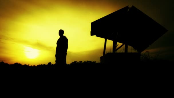 Silueta de un hombre al atardecer en el campo. La silueta de un hombre con un hacha en el viejo pozo. Silueta al atardecer Maderero, leñador. Hombre, naturaleza, puesta del sol . — Vídeo de stock