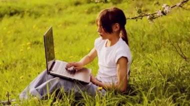 Bir dizüstü bilgisayar ile parkta beyaz çocuk. Doğa üzerinde bir dizüstü bilgisayar ile bir çocuk. Ülke çocuk genç dizüstü bilgisayar ile.