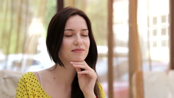 Caucásico, morena sentada en un café. Retrato de una hermosa joven. Hermosa joven mirando a la cámara. El concepto de belleza, felicidad, amor . — Vídeo de stock