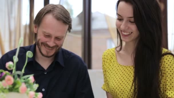 Kaukasiska par på ett kafé på en dejt. Ung man och kvinna pratar i en restaurang. Stilig man med en vacker flicka på en dejt. Begreppet kärlek, familj och mänskliga relationer. — Stockvideo