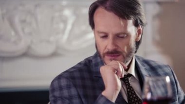 Beyaz adam üzgün Restoran beklentisiyle. Bir kadeh şarap ile bir restoranda yalnız bir adam portresi. Yalnız bir restoranda oturan genç şık işadamı.