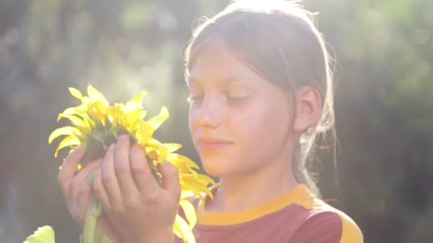 Porträtt av en pojke med en blomma solros. Kaukasiska tonåring med stor blomma solros. Tonårspojke att lukta en blomma solros. — Stockvideo