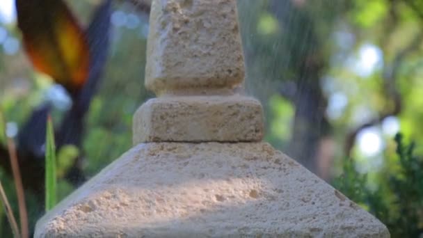 Japanese garden lantern in the rain. Raindrops falling on the Japanese stone lantern. — Stock Video