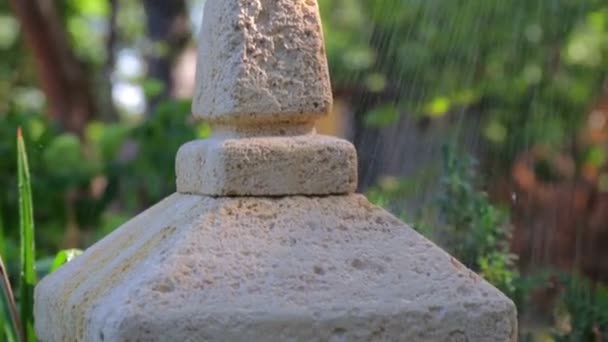 Linterna de jardín japonesa bajo la lluvia. Gotas de lluvia cayendo sobre la linterna de piedra japonesa . — Vídeos de Stock