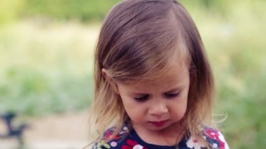 Beyaz küçük kız sosis mangal yiyor. Çocuk bir kız doğada yiyor. Emotsonalny çocuk sağlıklı gıda iştah açıcı yiyor. Bir yemek için bir çocuk portresi.