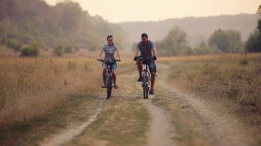 Doğada Bisiklete binme keyfini genç bir çift. Yürüyüş, Bisiklet kadın ve erkek. Genç çift bir alanda yürüyüş âşık. Spor, eğlence, yaşam biçimi.