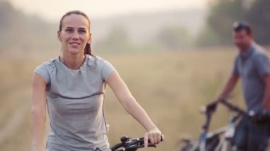 Doğada Bisiklete binme keyfini genç bir çift. Yürüyüş, Bisiklet kadın ve erkek. Genç çift bir alanda yürüyüş âşık. Spor, eğlence, yaşam biçimi.