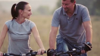 Doğada Bisiklete binme keyfini genç bir çift. Yürüyüş, Bisiklet kadın ve erkek. Genç çift bir alanda yürüyüş âşık. Spor, eğlence, yaşam biçimi.