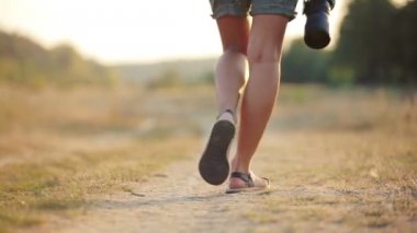 Ayak kız gazeteci el bir fotoğraf makinesi. Doğa kameraya olan kız. Bir kamera bir Safari ile genç bir kadın. Seyahat, turizm, macera.