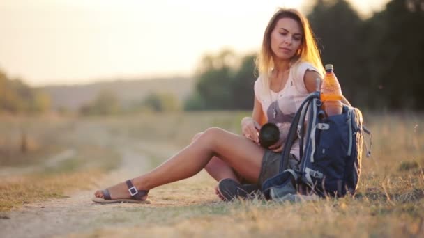 Bella giovane giornalista nella steppa. Ragazza con macchina fotografica sulla natura. Una giovane donna con una macchina fotografica in un safari. Viaggi, turismo, avventura . — Video Stock