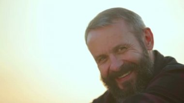 Bir adam hipster closeup portresi. Kameraya bakarak genç duygusal sakallı adam. Doğada sakallı adamın yüzünü.