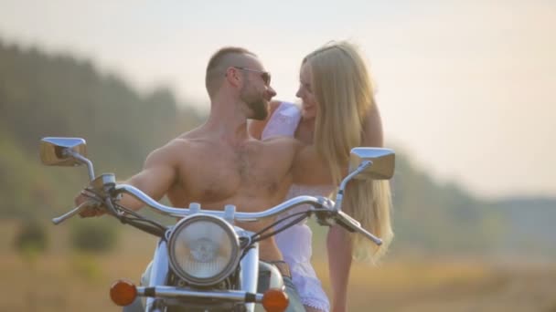 Muž a žena na motorce venku. Zamilovaná do mladého krásného páru na motorce v zemi.