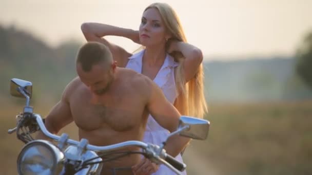 Hombre y mujer en una motocicleta al aire libre. Enamorado de una joven pareja hermosa en una motocicleta en el país . — Vídeos de Stock