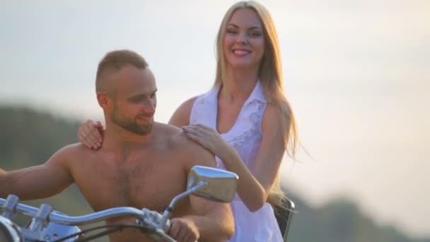 Mann und Frau auf einem Motorrad im Freien. verliebt in ein junges schönes Paar auf einem Motorrad auf dem Land. — Stockvideo