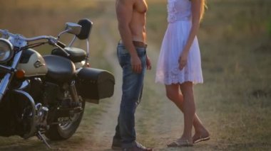 Dışarıda motosikletli bir kadın ve erkek. Ülkede bir motosiklet üzerinde genç bir güzel çift aşık.