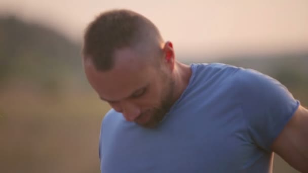 A young man and woman in the park at sunset. Happy young couple enjoying an intimate moment on the nature. Portrait of a young couple embracing and kissing. — Stock Video