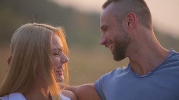Un jeune homme et une jeune femme dans le parc au coucher du soleil. Joyeux jeune couple profitant d'un moment intime sur la nature. Portrait d'un jeune couple embrassant et embrassant . — Video