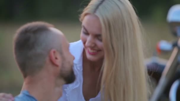 Man en vrouw op een motorfiets buitenshuis. Verliefd op een jonge mooie paar op een motorfiets in het land. Sport, recreatie, natuur. — Stockvideo