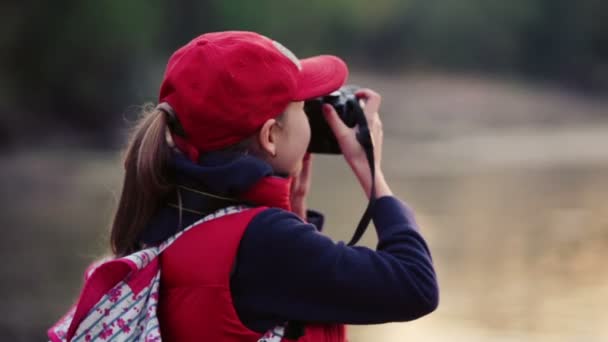 Niño isleduetsya naturaleza de la cámara. La chica viaja con una cámara . — Vídeos de Stock