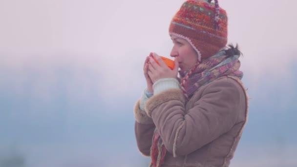 Giovane donna che beve tè all'alba. Ragazza con una tazza di tè all'alba . — Video Stock