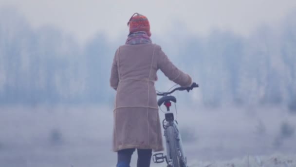 Kaukasisk kvinna i fältet av cykling. Ung kvinna cyklar över fältet. — Stockvideo