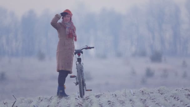 Mujer caucásica en el campo del ciclismo. Mujer joven montando una bicicleta a través del campo . — Vídeos de Stock