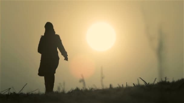 Una joven al amanecer. Chica joven se encuentra con nuevo día. La mujer corre, camina al amanecer del día . — Vídeos de Stock