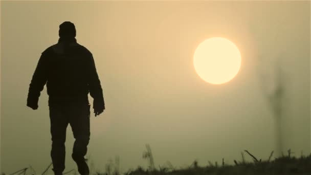 Кавказький чоловік, відпочиваючи в усамітнення на світанку. Молода людина в полі на світанку. — стокове відео