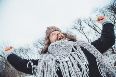 Komik genç adam doğada kış sakallı. Sonra adam ellerini yukarı sevinir kaldırdı kış.
