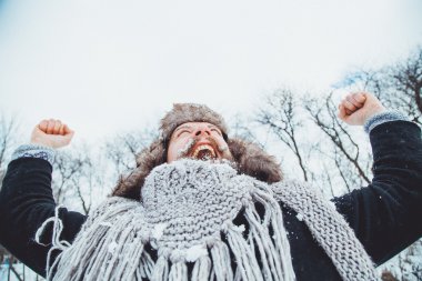 Komik genç adam doğada kış sakallı. Sonra adam ellerini yukarı sevinir kaldırdı kış.