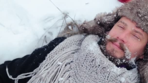 Portrait of a bearded man with an apple in the winter. A young bearded man eats an apple in the winter. The bearded man eating an apple to the camera in the winter. — Stock Video