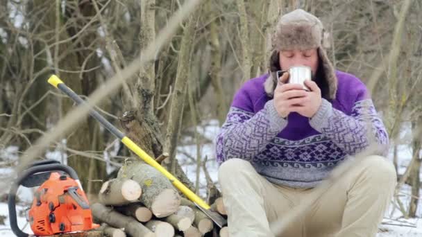 Skäggig man dricka te i skogen. Skäggiga skogshuggaren i vila under vintern. — Stockvideo