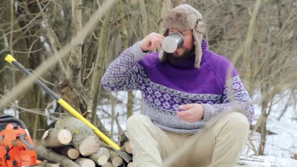 Bearded man drinking tea in the forest.Bearded woodcutter at rest in winter. — Stock Video