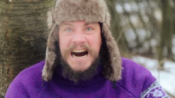 Porträt eines emotionalen Mannes mit Bart. das Gesicht eines bärtigen emotionalen Mannes im Winter. — Stockvideo