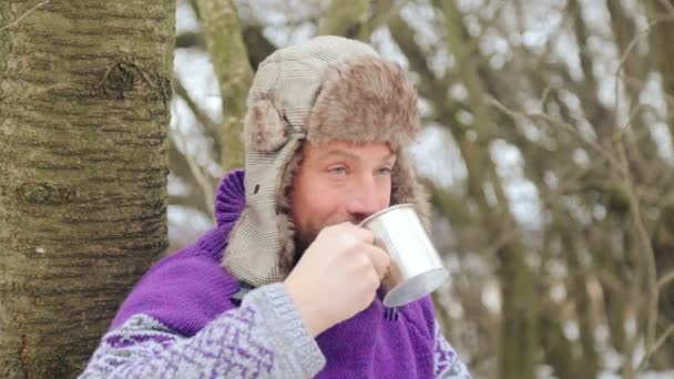 Hombre barbudo bebiendo té en el bosque. Cortador de madera barbudo en reposo en invierno . — Vídeos de Stock