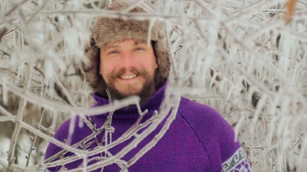 Retrato de un joven guapo con barba. Una persona cercana a un hombre barbudo. Barbudo hombre congelado en el bosque de invierno . — Vídeo de stock