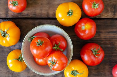 Ahşap zemin üzerinde sarı ve kırmızı domatesler. Üst görünüm.