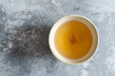 Boyanmış ahşap zemin üzerinde kil bardakta yeşil çay