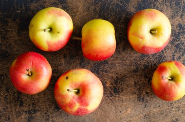 Soyut ahşap arka planda organik elmalar. Üst görünüm.