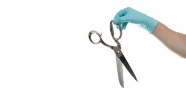 Doktorun eli eldivenli, beyaz arka planda izole edilmiş gümüş bir makas tutuyor.