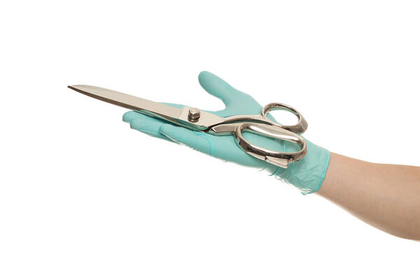 Doctor's hand in glove holding a silver scissor isolated over white background