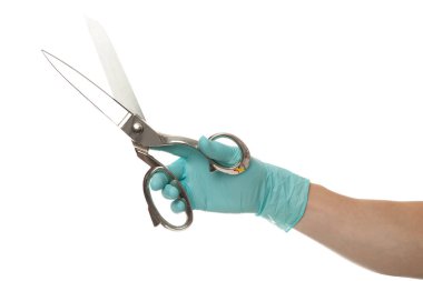 Doktorun eli eldivenli, beyaz arka planda izole edilmiş gümüş bir makas tutuyor.