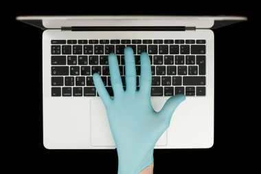 Eller dizüstü bilgisayarda yazan mavi koruyucu eldivenlerle. Üst Manzara. Coronavirus konsepti.