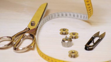 Ahşap arka planda izole edilmiş terzi aletleri. Makas, iğne, terzilik, el.